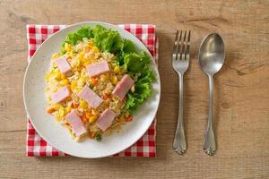 Homemade fried rice with ham and mixed vegetables of carrots, and green bean peas photo