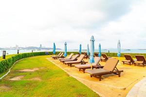 Chair pool or bed pool and umbrella around swimming pool with sea beach background at Pattaya in Thailand photo