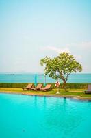 Chair pool and umbrella around swimming pool with ocean sea background photo