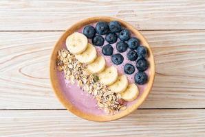 tazón de yogur o batido de yogur con bayas azules, plátano y granola - estilo de comida saludable foto
