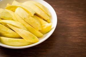 Fresh green and golden mango sliced on plate photo