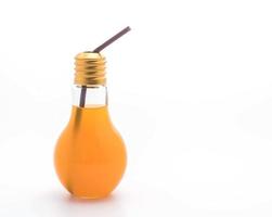 Orange juice in lamp shape glass on white background photo