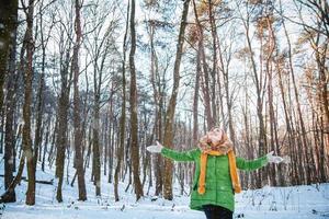 Retrato de invierno de una hermosa niña con sombrero y guantes foto