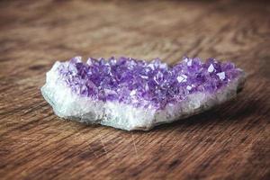 Purple amethyst crystal on a wooden background photo