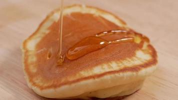 Hände gießen Honig auf leckere Pfannkuchen. video