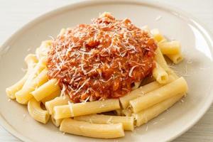 Rigatoni pasta with pork bolognese sauce - Italian food style photo