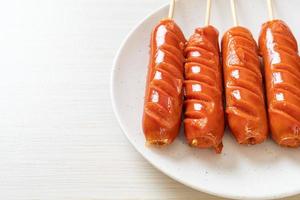 Fried sausage skewer on white plate photo