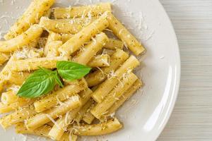 pasta al pesto rigatoni con queso parmesano - comida italiana y estilo vegetariano