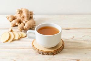 Fresh and hot ginger juice glass with ginger roots - Healthy drink style photo