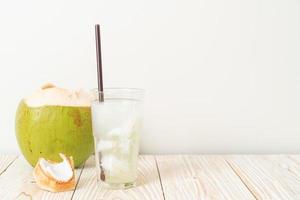 Coconut water or coconut juice in glass with ice cube photo