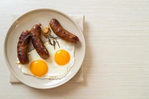 Homemade double fried egg with fried pork sausage - for breakfast photo