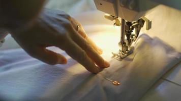 senior woman using sewing machine to sew clothes at home video