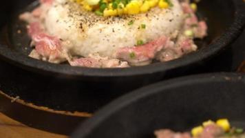 Carne de cerdo cruda con arroz en un plato caliente video