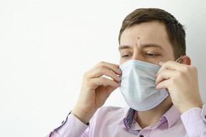 un hombre con camisa se pone una máscara. protección contra el virus. foto