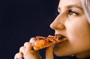 Girl eating pizza. Not healthy food. Home delivery. photo