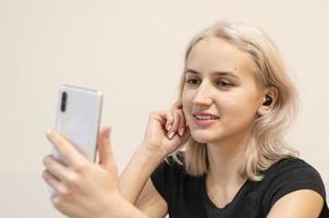 Girl communicates by video call. Wireless headphones. photo