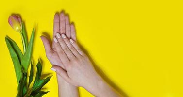 Female manicure on a bright background. Yellow photo