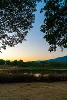 Beautiful lake at Chiang Mai with forested mountain and twilight sky in Thailand. photo