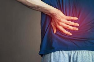 un hombre sosteniendo su espalda. dolor de espalda. foto