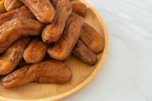 Sun-dried banana on wooden plate photo