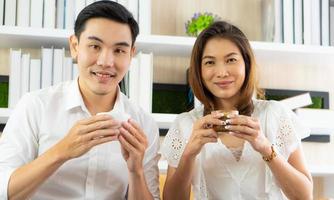 mujer asiática y hombre sentado en la cafetería y disfrutar bebiendo expreso foto