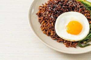 Homemade dried Korean spicy black sauce instant noodles with fried egg and kimchi photo