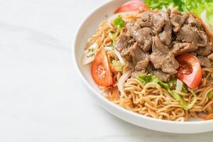 Instant noodle spicy salad with pork on white plate - Asian food style photo