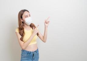 Portrait beautiful Asian woman wearing mask with hand presenting or pointing on white background photo