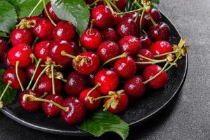 Fresh delicious red bright cherry berries torn in the summer garden photo