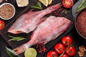 Raw fillet of red sea perch prepared for baking with spices and herbs photo