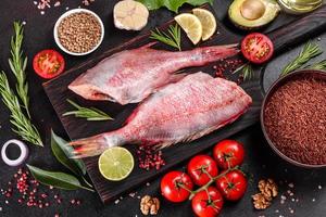 Raw fillet of red sea perch prepared for baking with spices and herbs photo