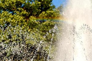 Selective focus on spray of urban fountain and blurred background photo