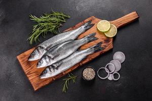 Lubina de pescado fresco e ingredientes para cocinar. pescado crudo lubina foto