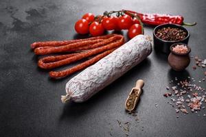 Spanish dried sausage salami on a dark concrete background