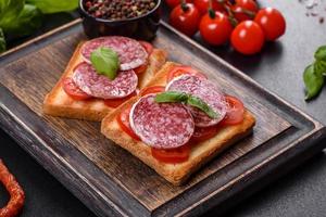 Spanish dried sausage salami on a dark concrete background photo