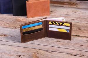 Hand made leather man wallet on wooden background photo