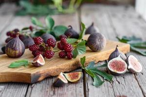 Fresh juicy figs and blackberries on a dark background photo