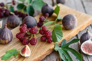 Fresh juicy figs and blackberries on a dark background photo