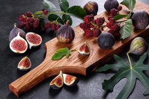 Fresh juicy figs and blackberries on a dark background photo