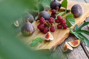 Fresh juicy figs and blackberries on a dark background photo