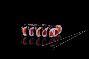 Rollos de sushi hermosos y deliciosos frescos sobre un fondo oscuro