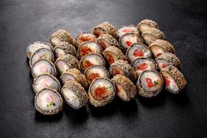Fresh delicious beautiful sushi rolls on a dark background photo