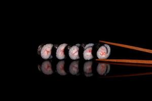 Fresh delicious beautiful sushi rolls on a dark background photo