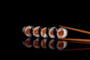 Fresh delicious beautiful sushi rolls on a dark background photo