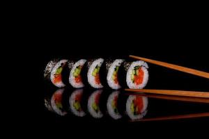 Fresh delicious beautiful sushi rolls on a dark background photo