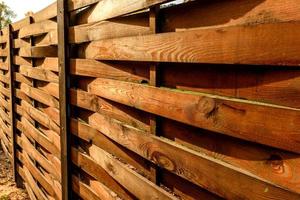 An old fence of wooden planks around a plot of land photo