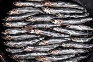 Several fish salted anchovies on a dark concrete table photo