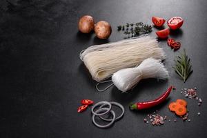 Tasty rice noodles with tomato, red pepper, mushrooms and seafood photo