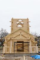 Construction of a Christian church made of wooden treated logs photo