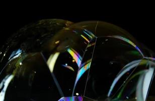 Soap bubble close up isolated on black background photo